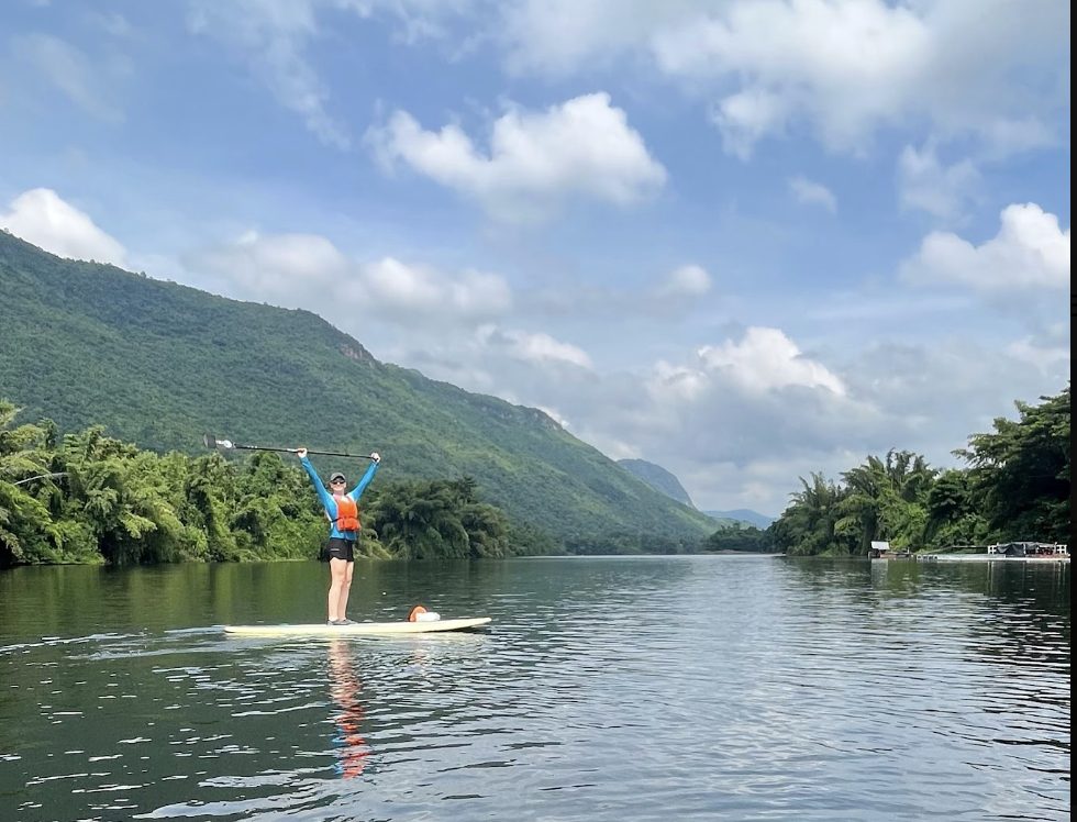 Olivia paddleboarding on a river during a residential trip